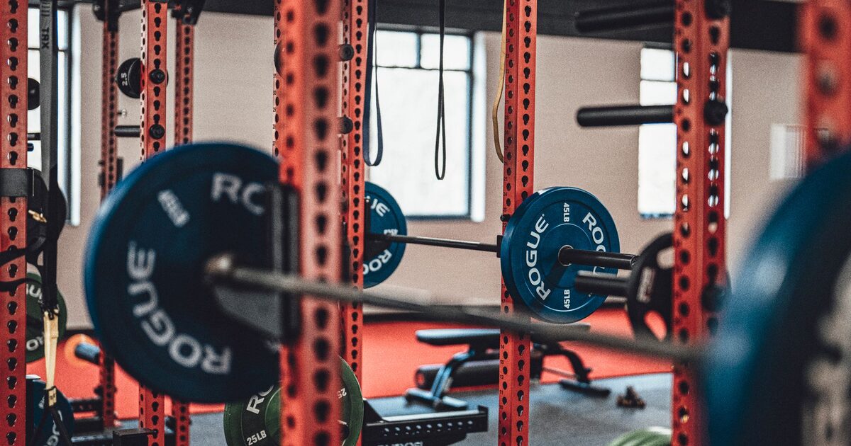 A lifter performing a barbell back squat in a gym